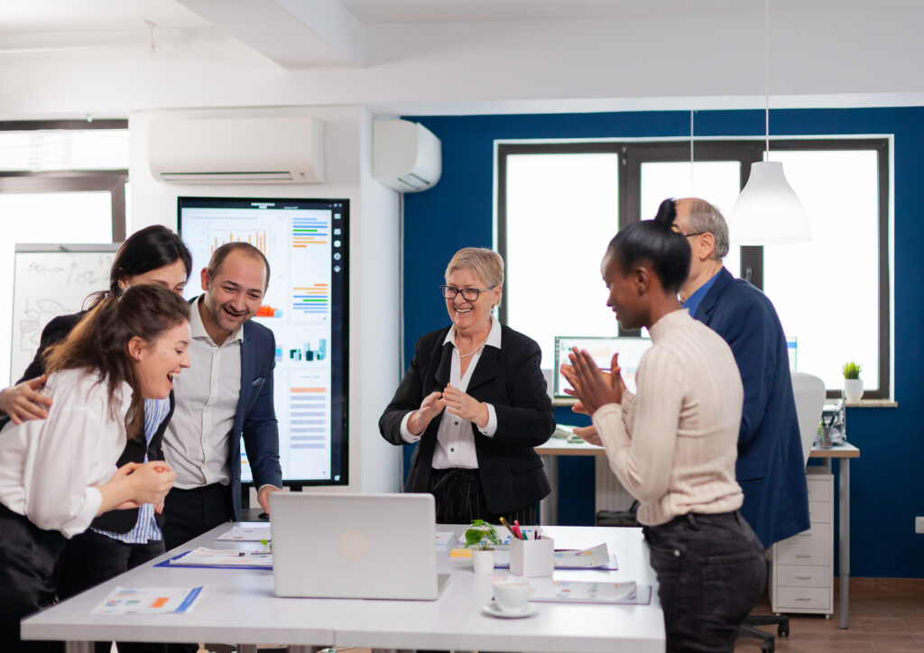 Team collaborating around a laptop in a professional and friendly environment